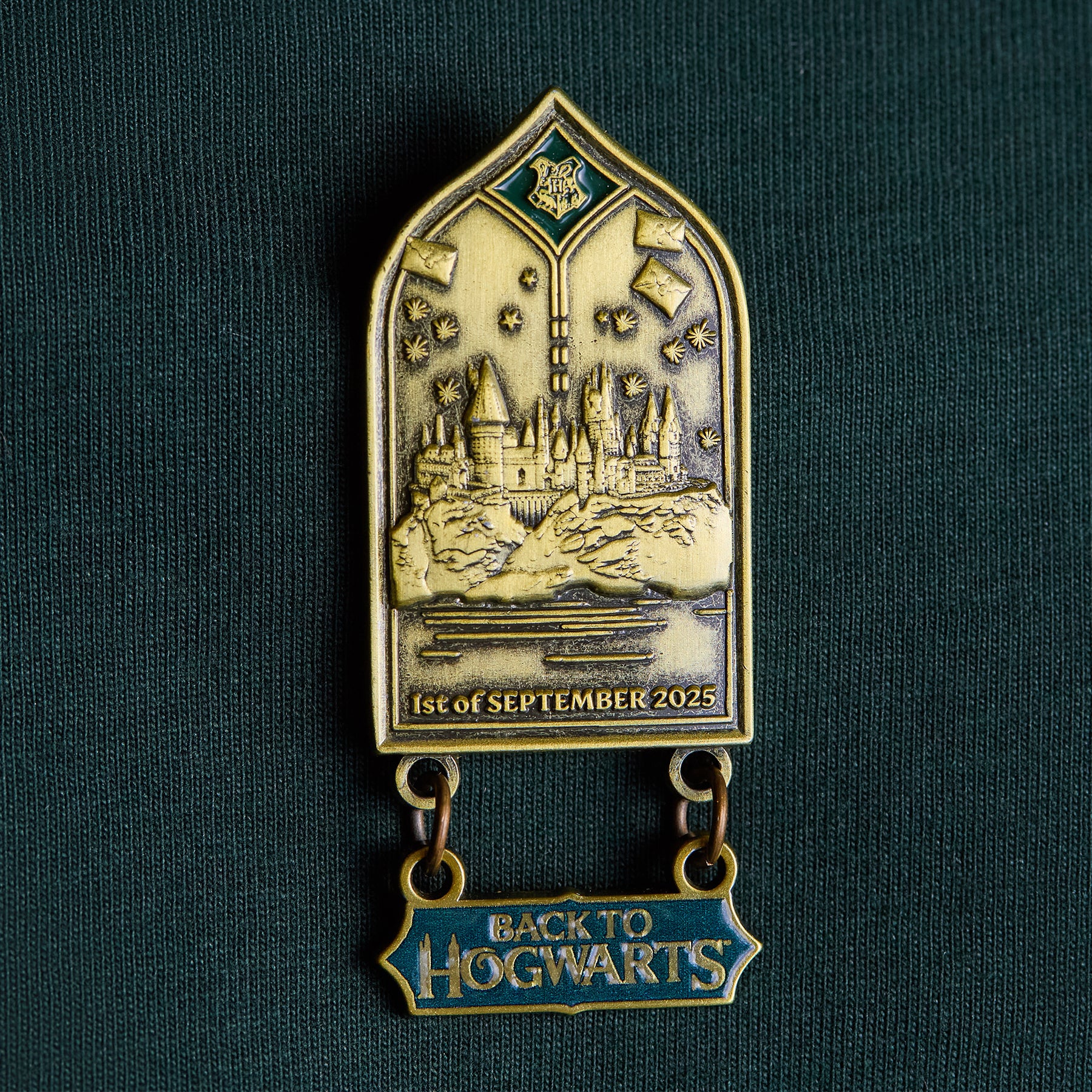 Pin badge with Hogwarts castle design and 'Back to Hogwarts' text on a green background
