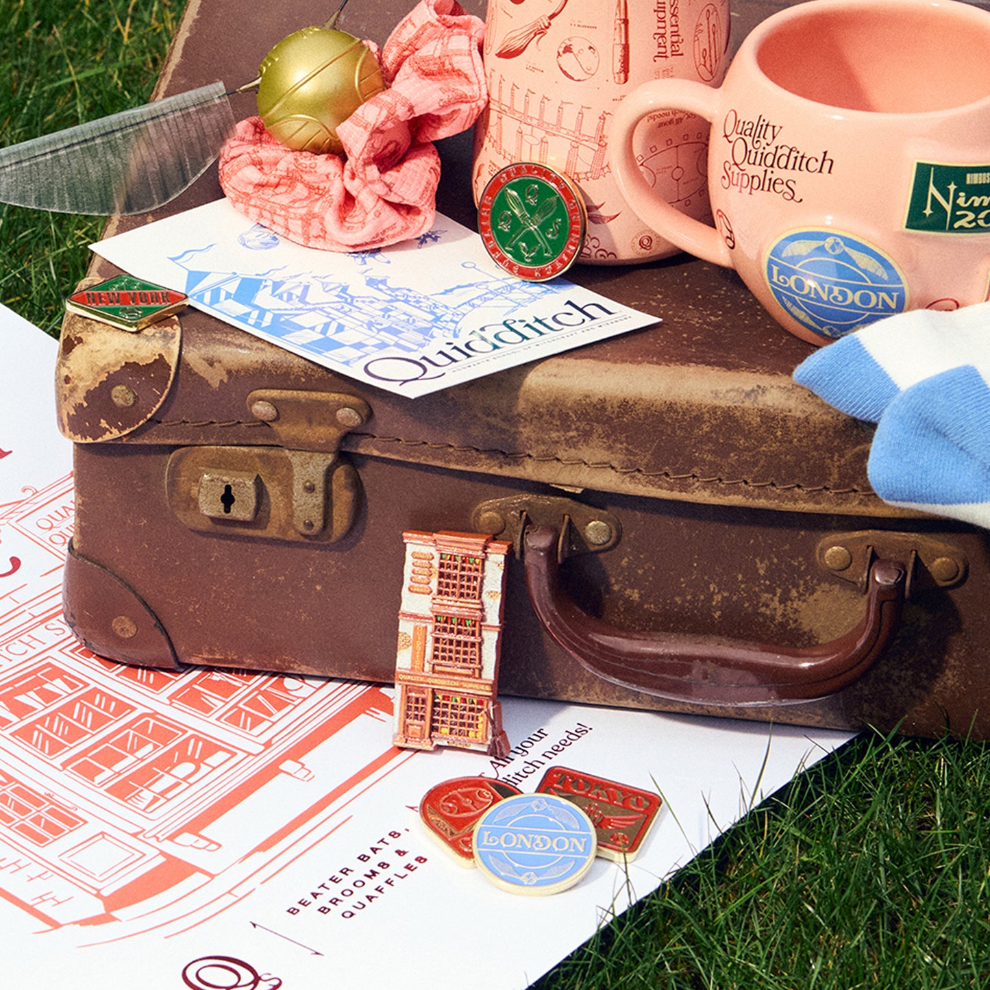 Vintage suitcase with Quidditch-themed items on a grassy background