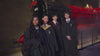 Four young people in Hogwarts robes standing in front of the Hogwarts Express